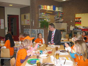 Foto van wethouder Herman Geerdes en leerlingen aan het ontbijt